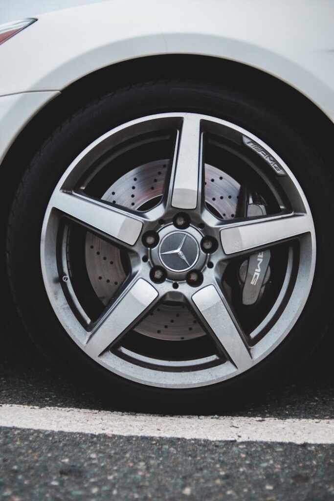 White shiny car wheel parked on street